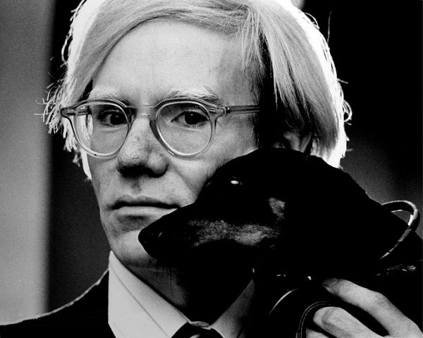 Portrait of Andy Warhol holding his dachshund Archie (1973)