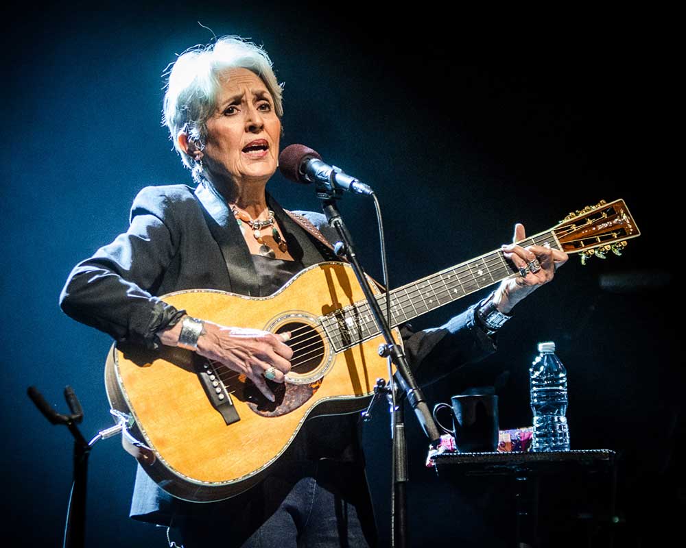 Joan Baez playing the guitar in 2016