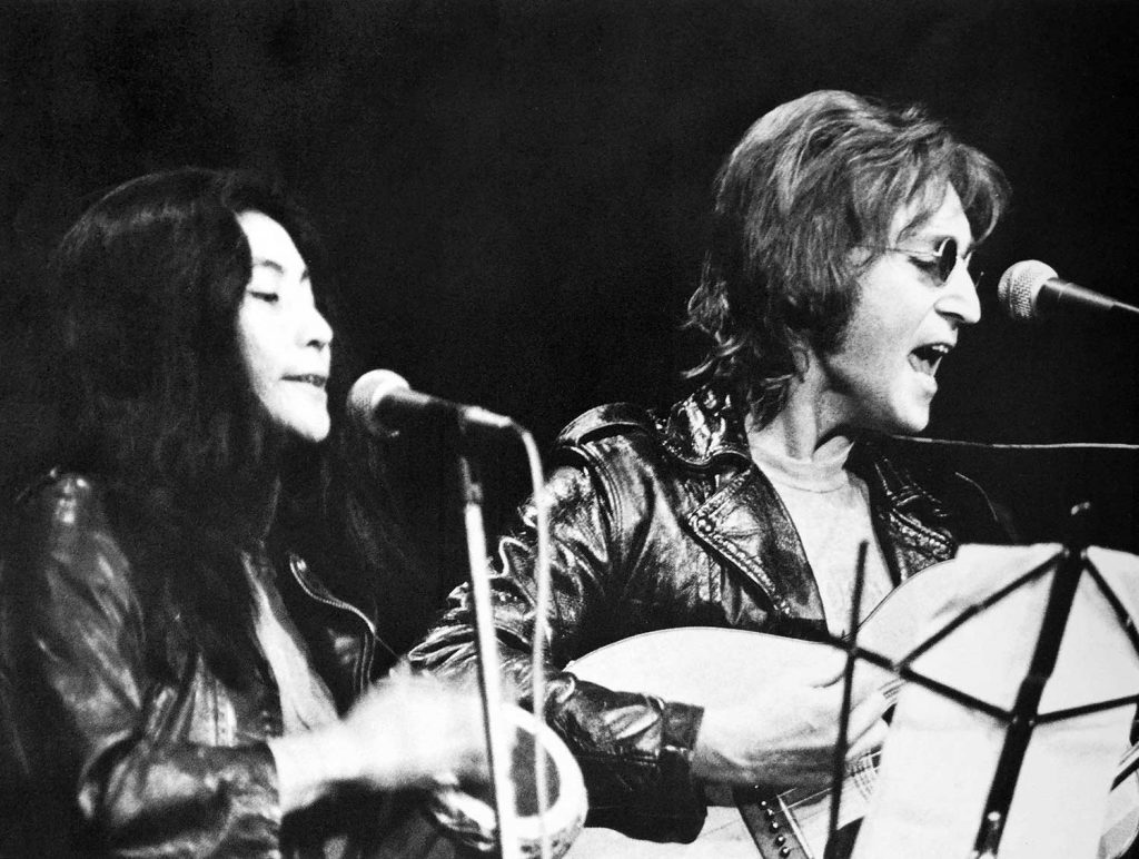 John Lennon (right) and Yoko Ono (left) performing at the John Sinclair Freedom Rally (1971)