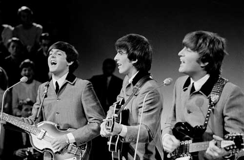 Paul McCartney (left), George Harrison (middle) and John Lennon (right) performing in 1964