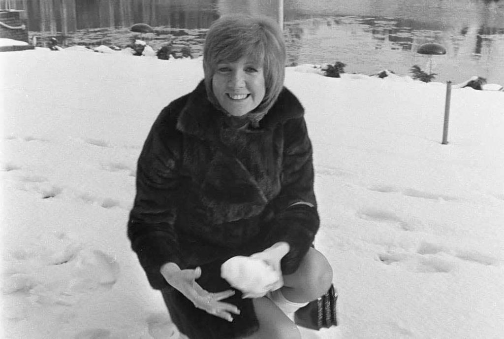 Cilla Black playing with fresh snow whilst on her visit to Amsterdam, Netherlands (1970)