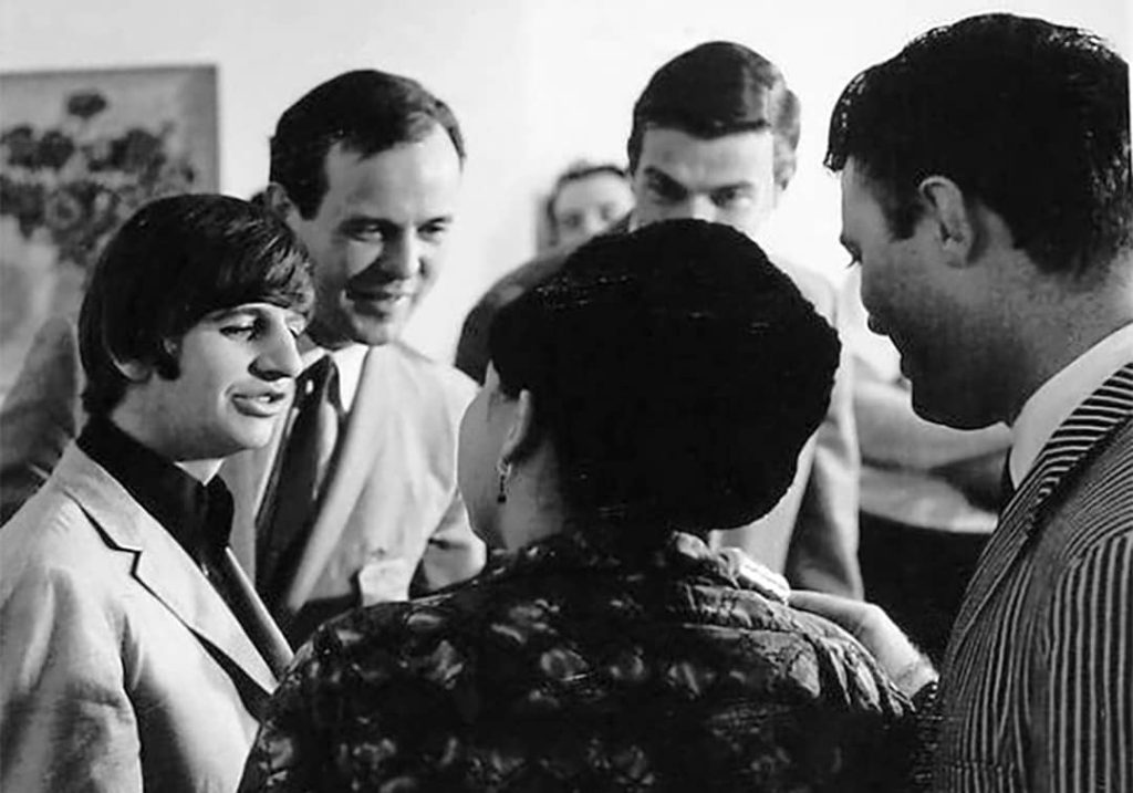 Photo of Ringo Starr (left) and who appears to be Brian Epstein (middle left), the identities of the other people shown in the photo are not known (1965)