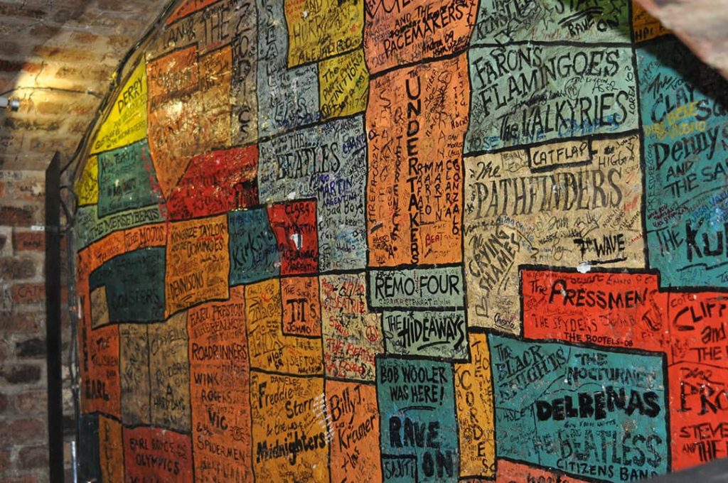 Wall at the back of the Cavern Club stage full of colourful signatures.