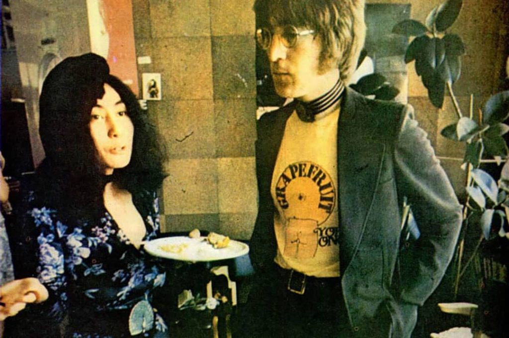 Yoko Ono and John Lennon having lunch from what it looks a catering table [not pictured] (1972)