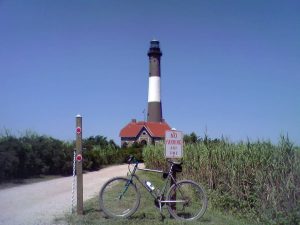 Photograph of the Fire Island lighthouse with a 'No Parking' sign and a bicycle, Long Island, New York, USA (2007)