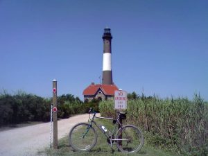 Photograph of the Fire Island lighthouse with a "No Parking" sign and a bicycle, Long Island, New York (2007)