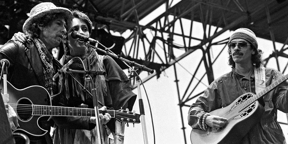 Bob Dylan (left), Joan Baez (middle), and Carlos Santana (right) performing in 1984