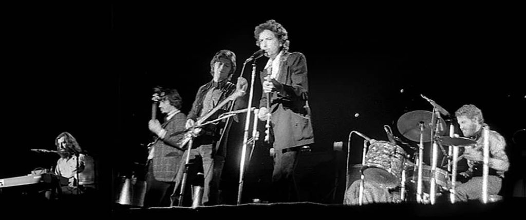 Picture of Bob Dylan (centre) and The Band performing (1974)